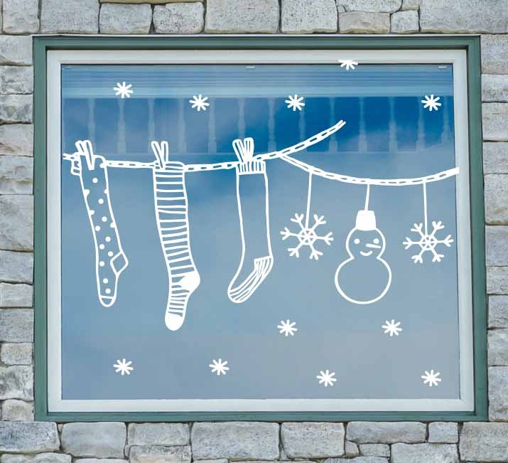Set de viniles electrostáticos con diseño de calcetas navideñas colocados en ventana decorada para Navidad